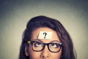 thinking-woman-with-question-mark-on-gray-wall-background