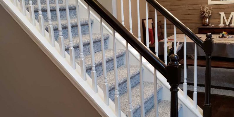 Image of recently refinished wood railing and staircase by Textbook Painting.